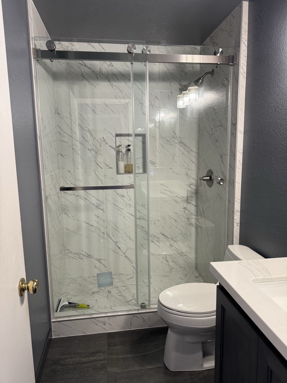Finished spa-style bathroom with a glass walk-in shower and marble tile by RP Precision