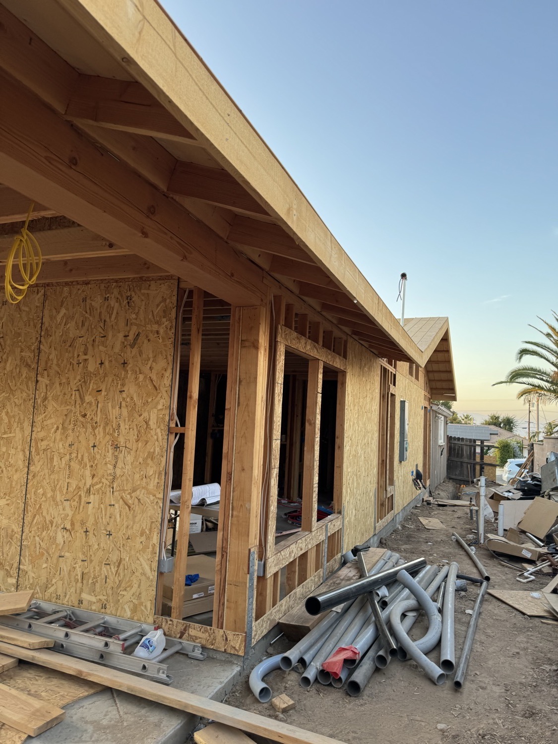 New construction framing taking shape on site at dusk
